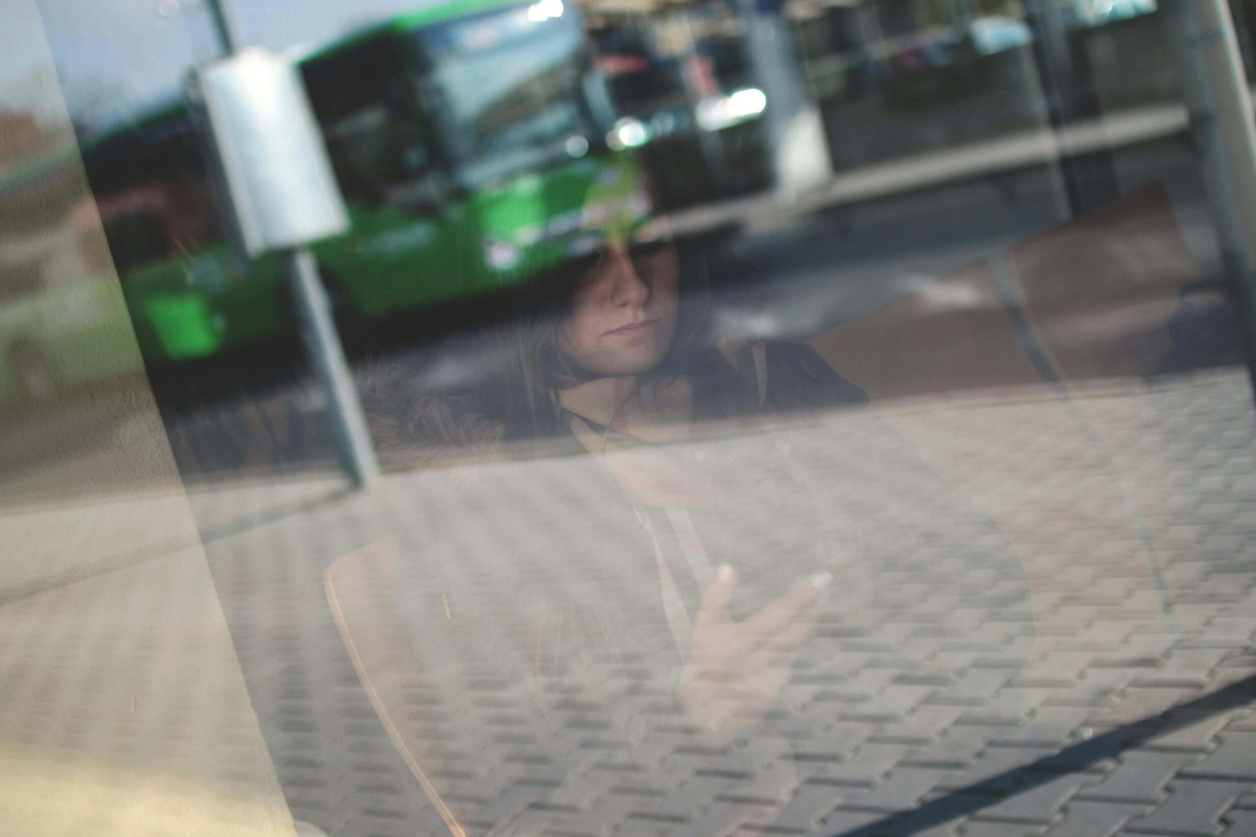 iemand kijkt vragend naar mobiel achter een raam
