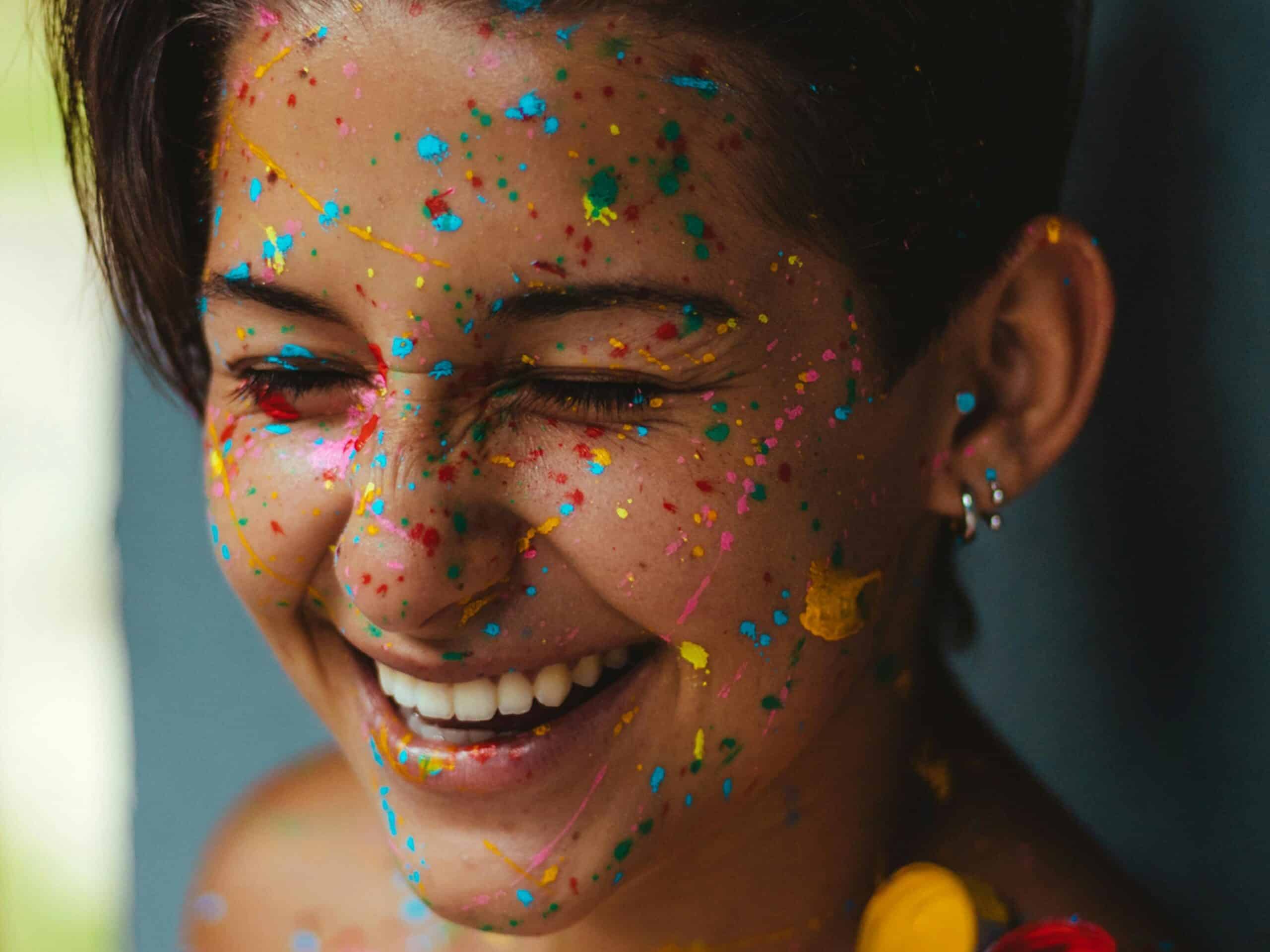 vrouw met regenboog glitters en verf in haar haren
